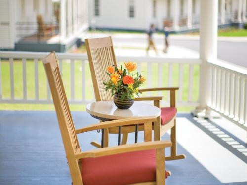 two chairs and a table with a vase of flowers on a porch at Cavallo Point in Sausalito