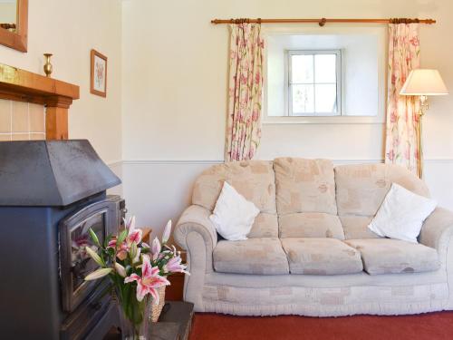 a living room with a couch and a fireplace at Hayloft - Ukc4241 in Lanreath