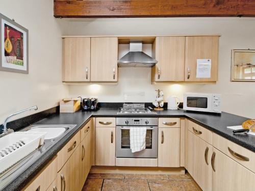 a kitchen with wooden cabinets and a sink at Hirst House - W41947 in Filey