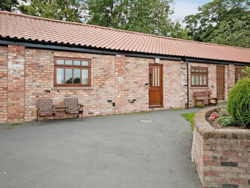 a brick building with a table and chairs in front of it at Hirst House - W41947 in Filey