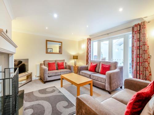 a living room with two couches and a table at The Willows in Sea Palling