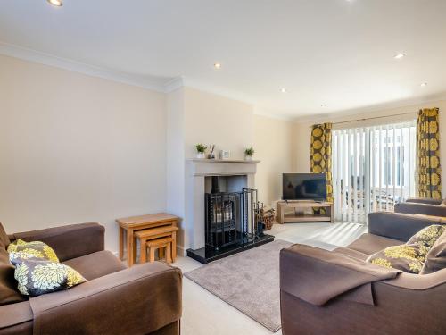 a living room with two couches and a fireplace at Sandbanks in Bacton