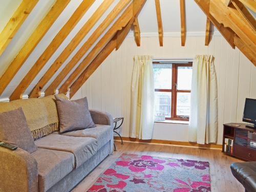 a living room with a couch and a window at Walnut Tree Cottage in Burbage