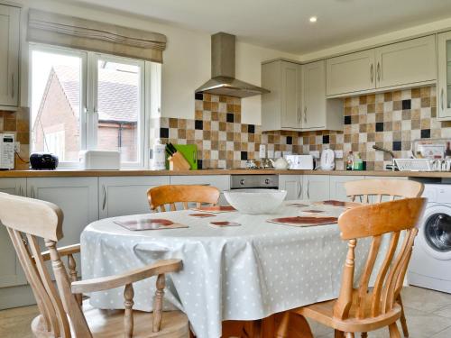 a kitchen with a table with a white table cloth at Hornbeam Cottage in Malvern Wells