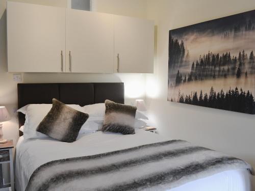 a bedroom with a bed with white cabinets at Barn Owl Bothy in Westward