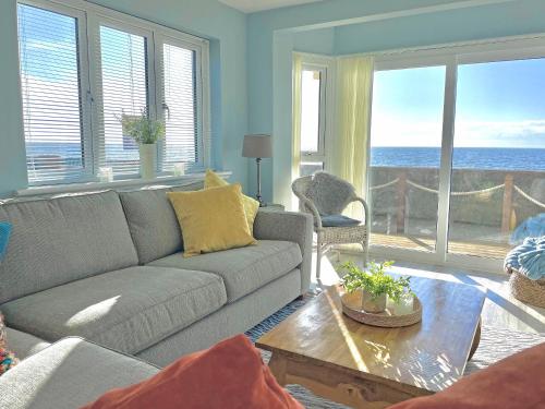 a living room with a couch and a view of the ocean at Point Clear View in Brightlingsea