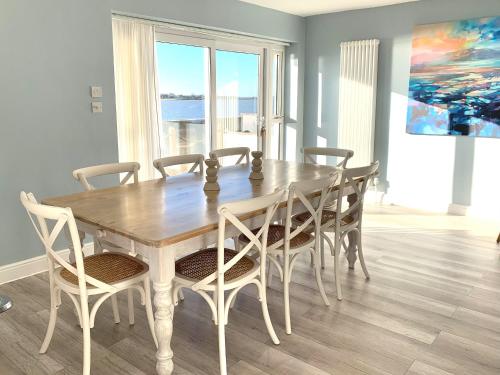 a dining room with a wooden table and chairs at Point Clear View in Brightlingsea