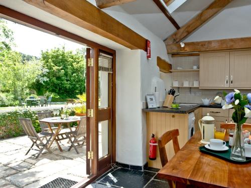 a kitchen with a table and a patio with a table at The Smithy in Chulmleigh