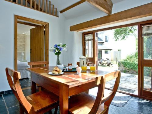 a wooden table in a room with a window at The Smithy in Chulmleigh