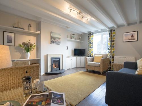 a living room with a couch and a fireplace at Cuthbert Cottage in Craster