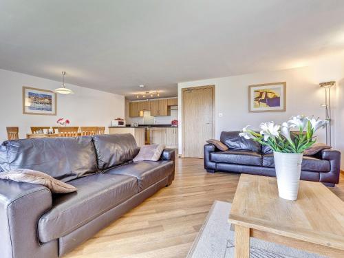 a living room with a leather couch and a table at 5 Red Rock Apartments in Dawlish Warren