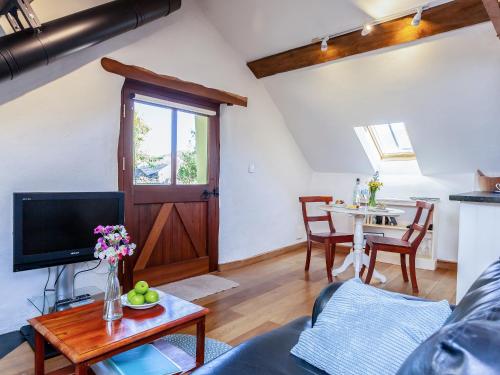 a living room with a couch and a table at Cider Barn in Chulmleigh