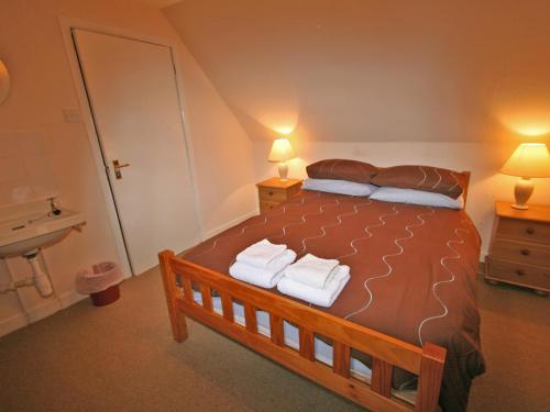 a bedroom with a large bed with towels on it at Melness Cottage in Melness