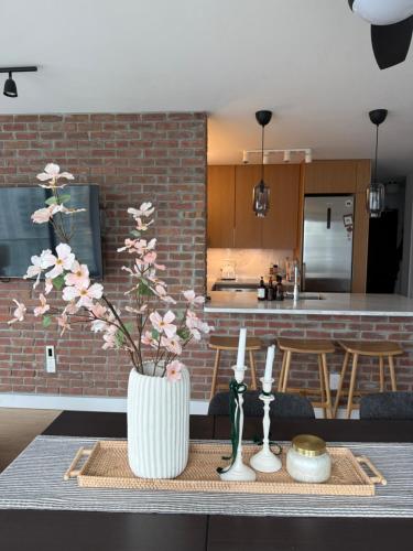 a table with a vase with flowers in a kitchen at Two Bedroom Apartment with stunning 180 water, mountain and city view Pool Hot Tub and Gym Heart of Downtown Skytrain 3mins walk Right by BC Place Rogers arena in Vancouver