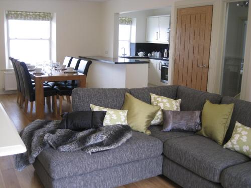 a living room with a couch and a dining room at Swallow's Nest in Bradwell