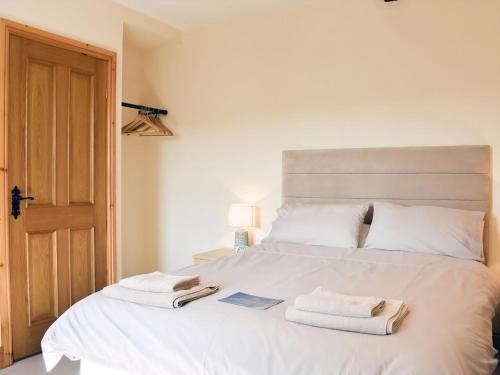 a bedroom with a white bed with towels on it at Gran's Cottage Askrigg in Askrigg