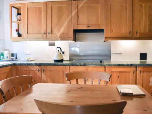 a kitchen with a wooden table with a tea kettle on it at Gran's Cottage Askrigg in Askrigg