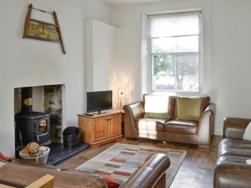 a living room with a couch and a fireplace at Viewington Lodge in Ballater