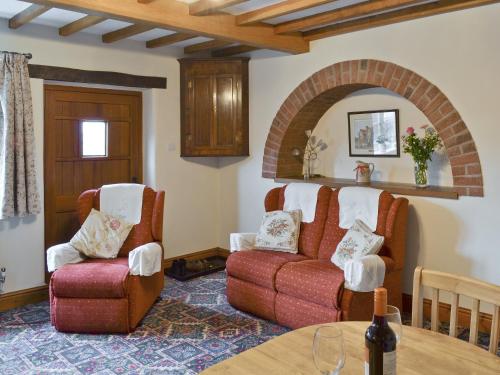 a living room with two chairs and a couch at Farmhouse Cottage in North Rode