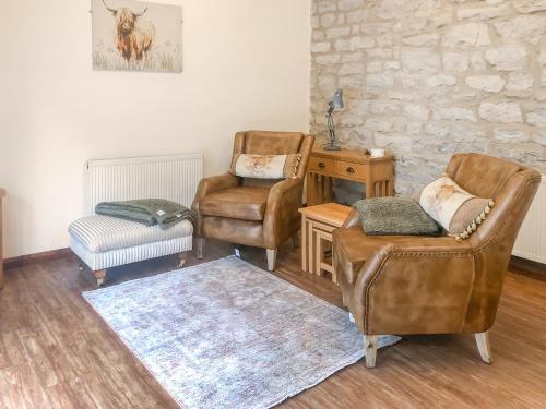 a living room with two chairs and a table at Plum Tree Cottage in Kirkbymoorside