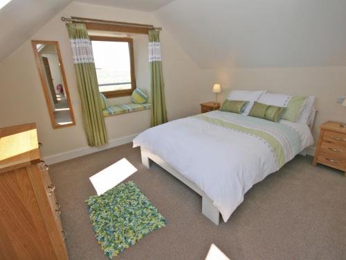 a bedroom with a bed and a window and a mirror at Cairndoon Steading Whithorn in Carlton