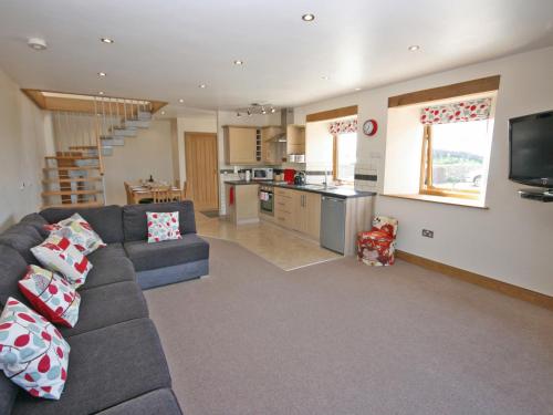 a living room with a couch and a kitchen at Cairndoon Steading Whithorn in Carlton