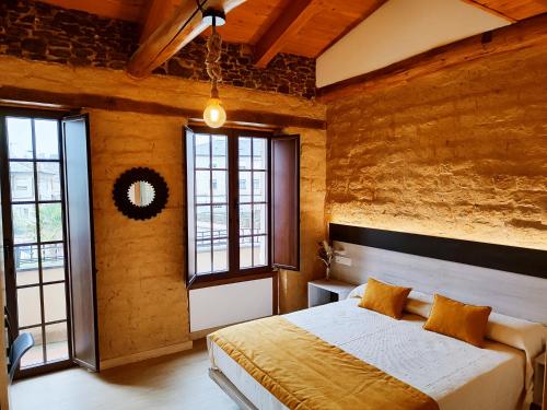 a bedroom with a bed and two windows at Hostal Restaurante LA SENDA in Camponaraya