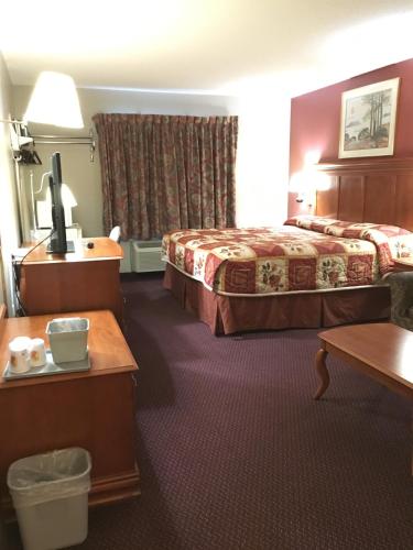 Cette chambre comprend 2 lits et une table. dans l'établissement Becker inn & Suites, à Becker