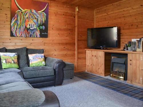a living room with a couch and a flat screen tv at Loch Arkaig in Banavie
