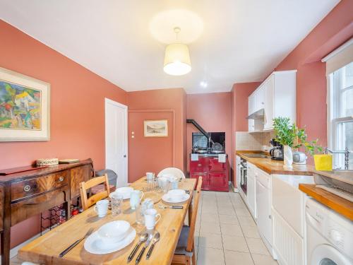 a kitchen with a wooden table and a dining room at Rhoda's Cottage in Strachur