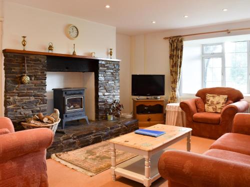 a living room with a fireplace and a tv at Holly - Ukc4243 in Lanreath