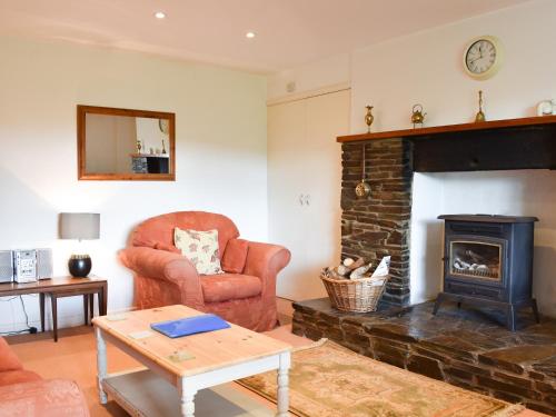 a living room with a chair and a fireplace at Holly - Ukc4243 in Lanreath