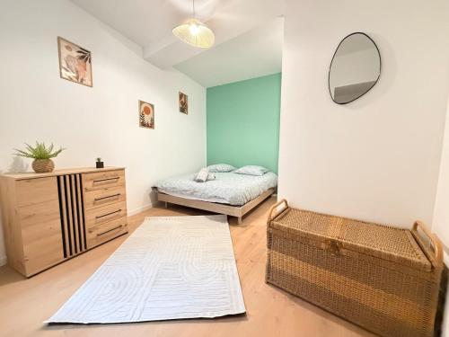a bedroom with a bed and a dresser and a mirror at Le Nid Laonnois Apartment in Laon