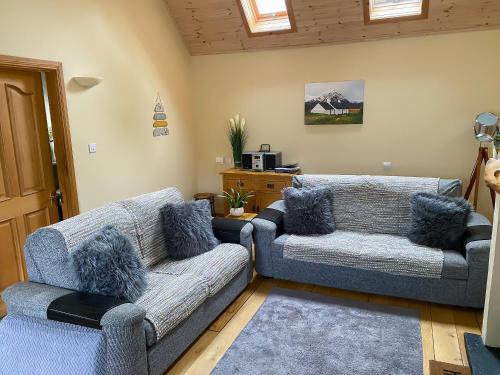a living room with two couches and a table at Glenfruin Lodge in Helensburgh