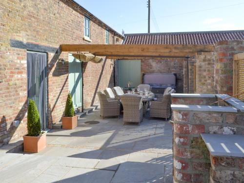 an outdoor patio with wicker chairs and a table at The Granary Uk13197 in Butterwick