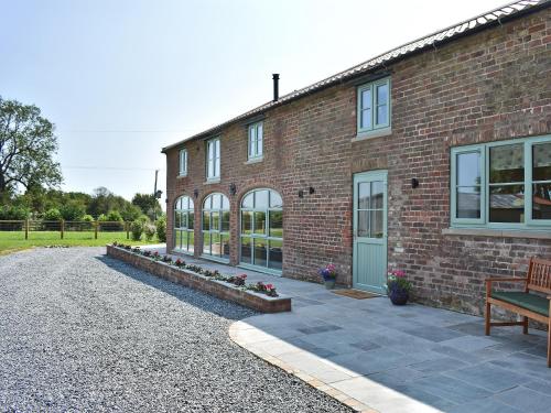 a brick building with a bench in front of it at The Granary Uk13197 in Butterwick