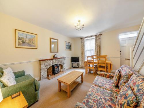 a living room with a couch and a fireplace at Tweed Cottage in Alnwick