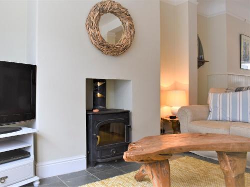a living room with a wood stove and a couch at Sea Star Cottage in Fowey