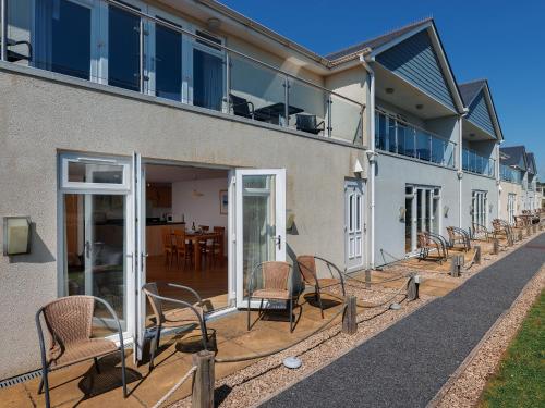 a group of chairs sitting on a patio at 2 Red Rock Apartments in Dawlish Warren