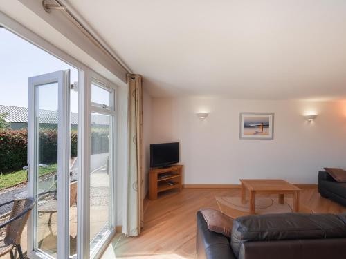 a living room with a couch and a tv at 2 Red Rock Apartments in Dawlish Warren