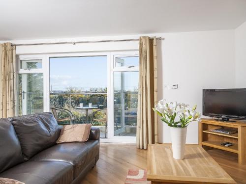 a living room with a couch and a tv at 14 Red Rock Apartments in Dawlish Warren
