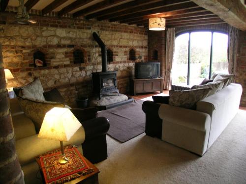 a living room with two couches and a fireplace at Spring Farm Barn in Grindale