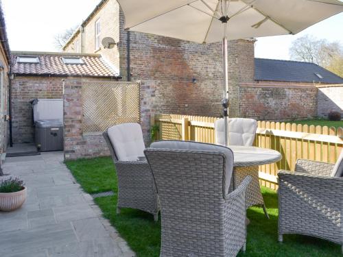 a patio with a table and chairs and an umbrella at The Dairy Uk13198 in Butterwick