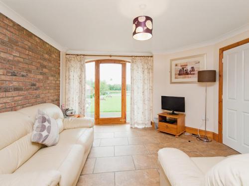 a living room with a couch and a tv at Close Cottage - W41944 in Filey