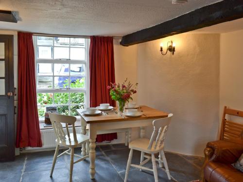 a dining room with a table and chairs and a window at Brock Cottage in Broughton in Furness