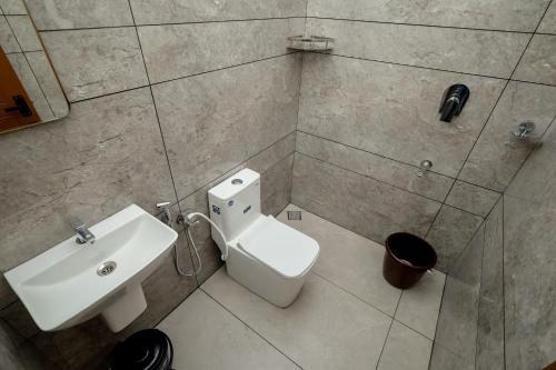 a bathroom with a white toilet and a sink at Royal La Casa in Cochin