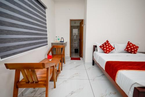 a bedroom with a bed and a table and chairs at Royal La Casa in Cochin