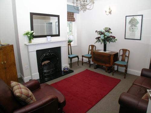 a living room with a fireplace and a red rug at Ted's House in Mytholmroyd