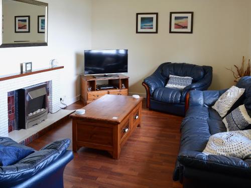 a living room with two couches and a television at Deo Na Mara in Midtown Brae