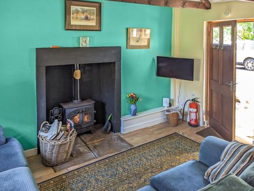 a living room with a couch and a fireplace at Port Righ Cottage in Carradale